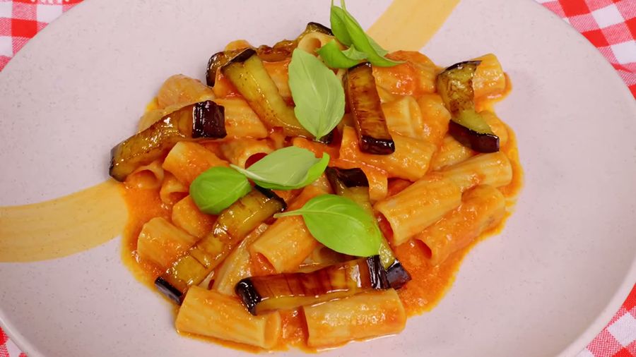 Pasta alla Norma — rigatoni in smooth tomato sauce topped with honey-glazed fried eggplant and fresh basil